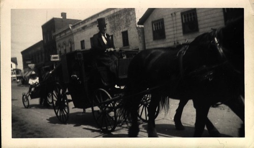 Closed carriage with formally attired Wicks Board driving followed by a sulky downtown in 100th Hambletonian Anniversary Parade, May 5, 1949. chs-003444